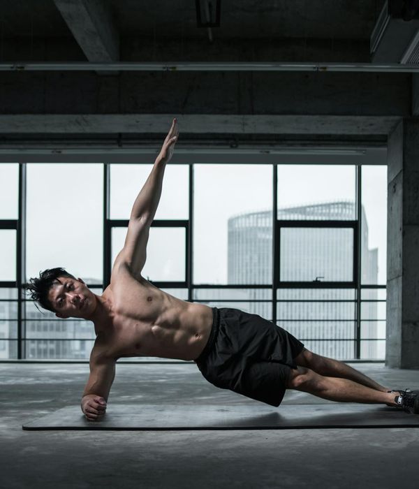 Man performing strength exercises focusing on core stability in gym